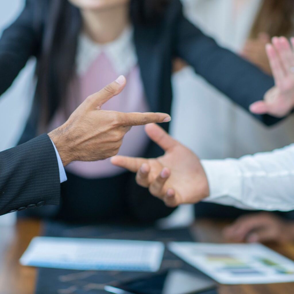 how to disagree professionally in english featured A group of people having a heated workplace discussion, showing different opinions and disagreement.
